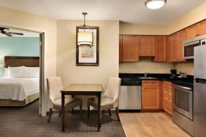 a kitchen and dining room with a table and a bed at MainStay Suites in Grand Rapids +3 photos