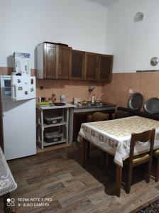 kuchnia ze stołem i białą lodówką w obiekcie Issy Apartment w Sarajewie