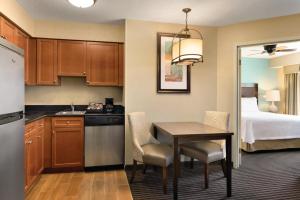 cocina y comedor con mesa y cama en Homewood Suites Grand Rapids en Grand Rapids