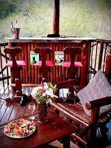 a table with a plate of food and a glass of wine at Majuli River House in Marloth Park