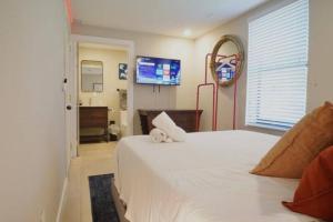 een slaapkamer met een groot wit bed en een televisie bij Comfortable Family Apt: 2 Beds, 2 Bath in Miami