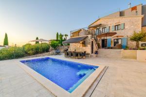 a villa with a swimming pool in front of a house at Casa Mar in Mugeba