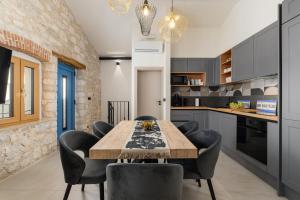 a kitchen with a wooden table and black chairs at Casa Mar in Mugeba