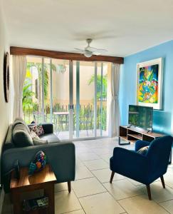 a living room with a couch and a tv at El Colorín, a condo in the heart of Huatulco in Santa Cruz Huatulco