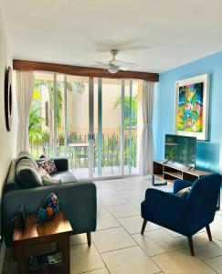 Una sala de estar con un sofá y un televisor. en El Colorín, a condo in the heart of Huatulco, en Santa Cruz Huatulco