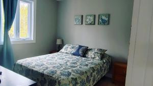 um quarto com uma cama e duas fotografias na parede em Chalet Mathis em Saint-Raymond