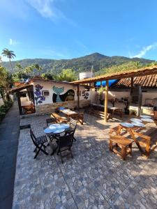 a patio with tables and chairs and a building at Ilha Grande Inn in Abraão