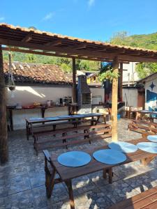 a group of wooden picnic tables on a patio at Ilha Grande Inn in Abraão