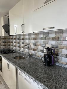 a kitchen with a sink and a counter top at Tirebolu Kaplan Apartman 