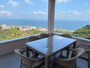 a table and chairs on a balcony with a view of the ocean at Tirebolu Kaplan Apartman 
