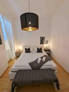 a bedroom with a large bed and a chandelier at Luxury CityApartment 7 in Vienna