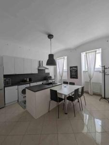 a white kitchen with a table and chairs in it at Luxury CityApartment 7 in Vienna