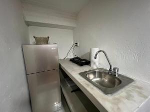 a kitchen with a sink and a refrigerator at Urban Hotel in Guatemala