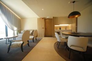 a living room with a table and chairs and a kitchen at Casa do Soutinho in Alvarenga