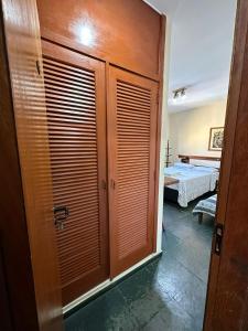 a room with wooden doors and a bedroom with a bed at Suíte no centro de Angra dos Reis - 13 in Angra dos Reis