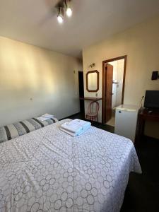 a bedroom with a bed with a white comforter at Suíte no centro de Angra dos Reis - 13 in Angra dos Reis