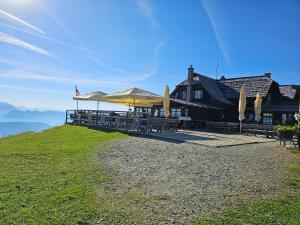 a restaurant with tables and umbrellas on a hill at Gerlitzen-Apartments in Kanzelhöhe