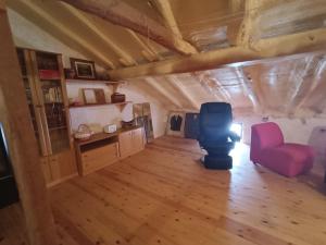 a living room with a red chair and a desk at Paloma Blanca in Espinosa de Villagonzalo
