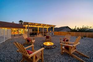 einen Hinterhof mit Schaukelstühlen und einer Feuerstelle in der Unterkunft JoshuaTree N.P. Oasis *Views* Pool/Spa/BBQ in Yucca Valley