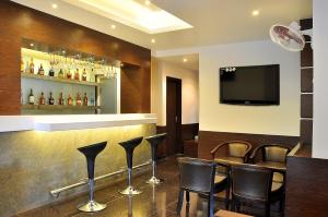 a bar with black chairs and a flat screen tv at Shree Narayana Hotel-BAR-Rooftop Terrace-Disc in Udaipur