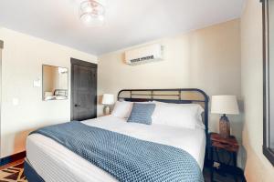 een slaapkamer met een bed met een blauwe en witte deken bij Rost Place Rambler in Sturgis