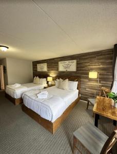 a hotel room with two beds and a table at Timber Ridge Lodge - Walking Distance from Downtown Gatlinburg in Gatlinburg
