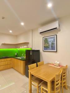 a kitchen with a wooden table and a green counter at Quân's homestay in Ho Chi Minh City
