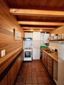 a kitchen with wooden cabinets and a stove top oven at Apartamentos céntricos en San Martin de los Andes. in San Martín de los Andes