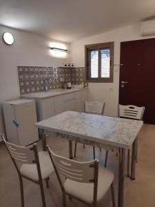 a kitchen with a table and chairs and a counter at אשל ציפורה in Arad