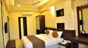 een hotelkamer met een bed en een spiegel bij Shree Narayana Hotel-BAR-Rooftop Terrace-Disc in Udaipur