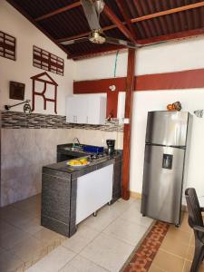 Una cocina con refrigerador de acero inoxidable en una habitación. en Rancho Ayala, en Santa Marta