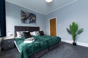 1 dormitorio con 1 cama con manta verde en Newly Renovated Perfect Family Home in Nottingham en Nottingham