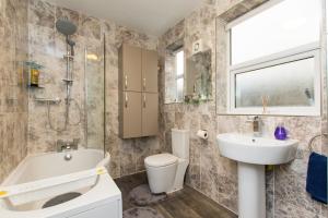 a bathroom with a tub and a toilet and a sink at Newly Renovated Perfect Family Home in Nottingham in Nottingham