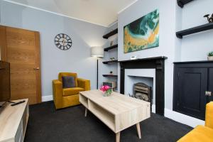 a living room with a fireplace and a table at Newly Renovated Perfect Family Home in Nottingham in Nottingham