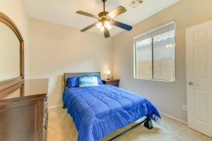 um quarto com uma cama azul e uma ventoinha de tecto em Maricopa Vacation Rental with Covered Patio! em Maricopa