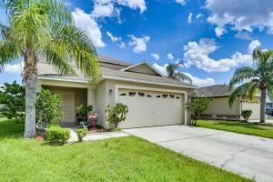 a palm tree in front of a house with a garage at 2 Mi to Epperson Lagoon Home with Private Yard in Wesley Chapel