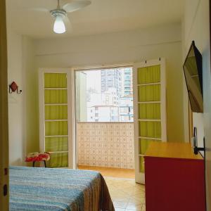 a bedroom with a bed and a large window at Santos frente ao mar in Santos