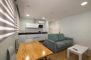 una sala de estar con una silla verde y una mesa en ALQUILAZ Apartamentos Turísticos en Zamora