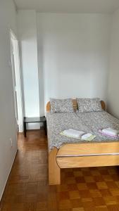 a bed in a room with a wooden floor at Confluence Apartment in Belgrade