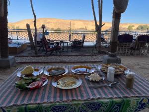 a table with plates of food on top of it at Amir Nile Guest house in Aswan