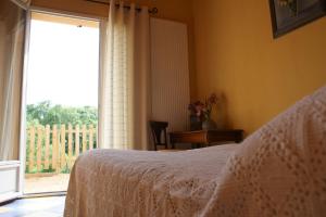 - une chambre avec un lit et une grande fenêtre dans l'établissement Maison d'Hotes du Vert Vallon, à Theizé
