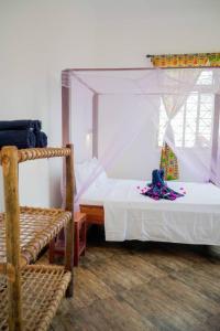Un dormitorio con 2 camas y una silla. en MOYOWANGU HOUSE PAJE, en Paje