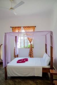 Un dormitorio con una cama con almohadas rojas. en MOYOWANGU HOUSE PAJE en Paje