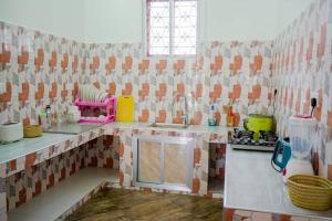a tiled kitchen with a sink and a counter at MOYOWANGU HOUSE PAJE in Paje