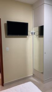 a flat screen tv on a wall in a room at Pousada Jaguary in Bragança Paulista