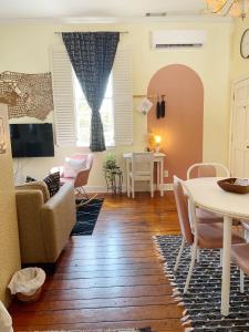 a living room with a table and chairs at 1885 Vintage Parlor Loft: Heart of Historic SAV in Savannah