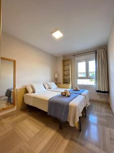 a bedroom with two beds and a large window at Manolete in Córdoba