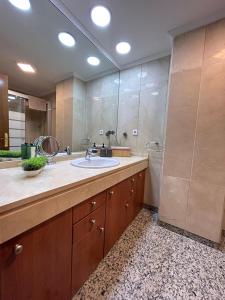 ein Badezimmer mit einem Waschbecken und einem großen Spiegel in der Unterkunft Manolete in Córdoba