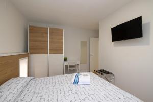 A television and/or entertainment centre at ALQUILAZ Apartamentos Turísticos