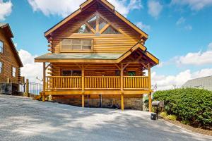 a large wooden cabin with a porch on a street at A Walk in the Clouds in Pigeon Forge